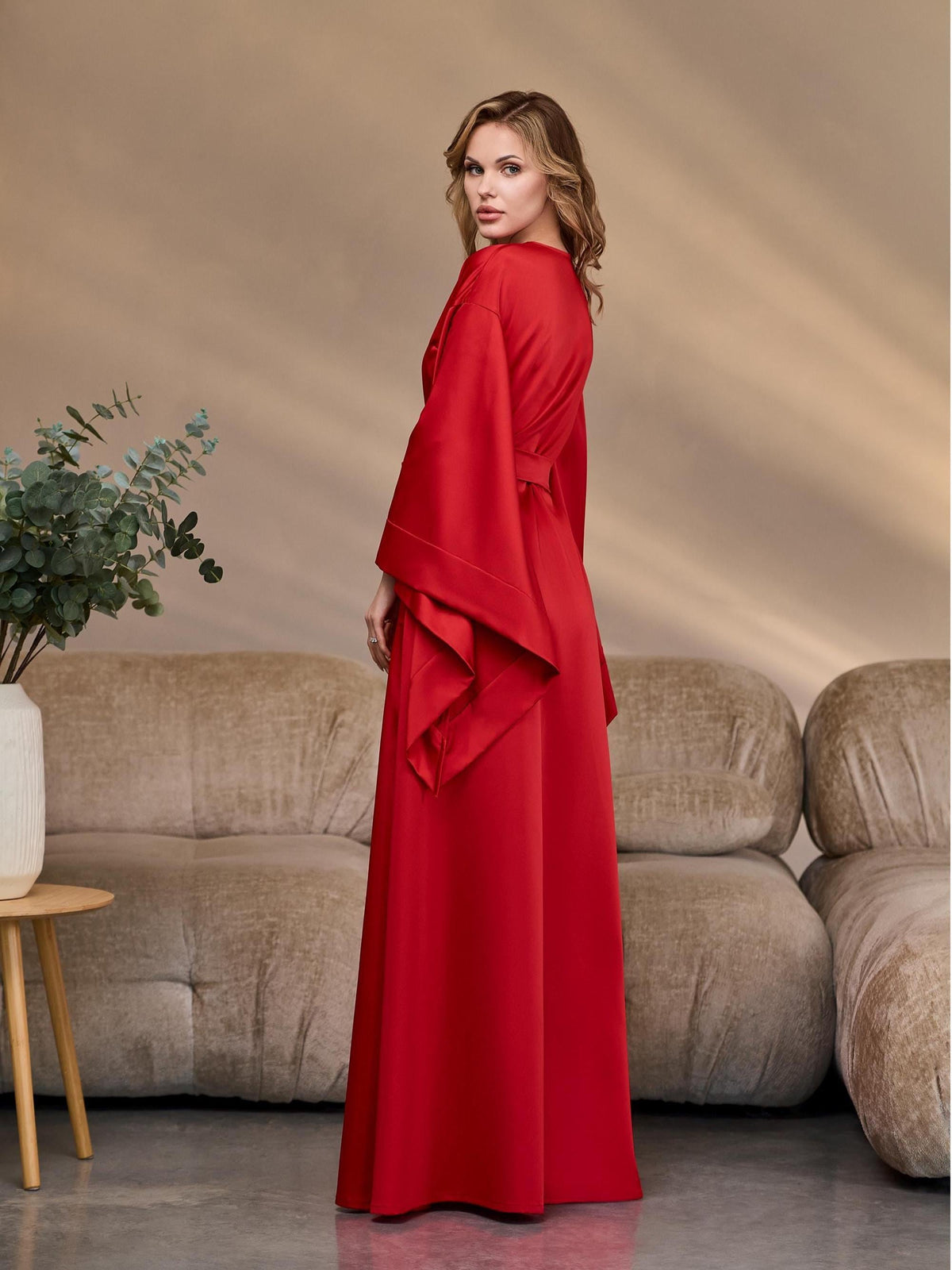 Side view of a red long satin kimono robe with belted waist