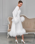 Side view of white satin bridal robe with feather trim on the cuffs and hem