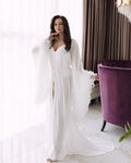 a woman in a white dress standing in a room