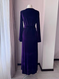 Back view of full-length purple velvet dressing gown with waist belt and flowing fabric.