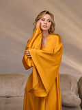 Close-up of wide gold satin kimono sleeves and glossy fabric on model