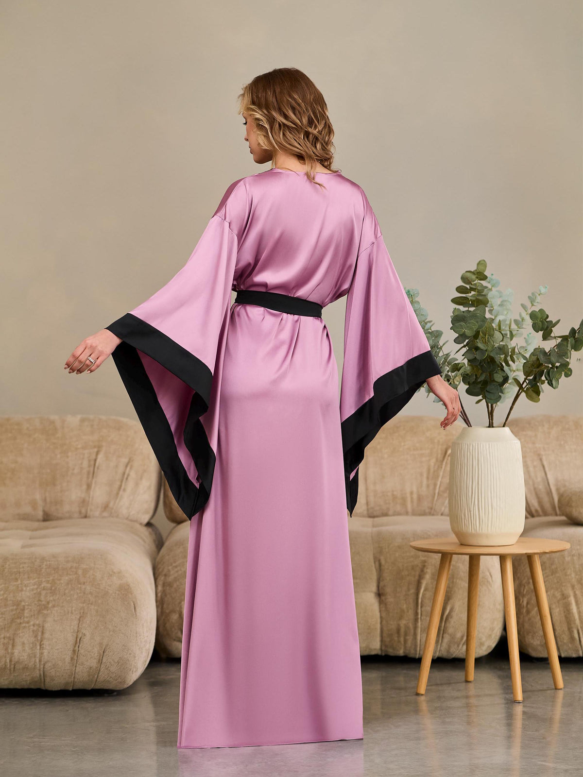 Purple floor length wrap robe showing black contrast trim and elegant silhouette