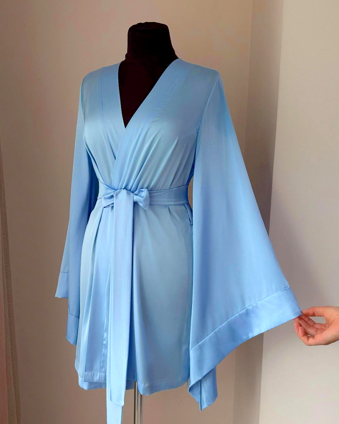 a woman's hand is holding onto a blue robe