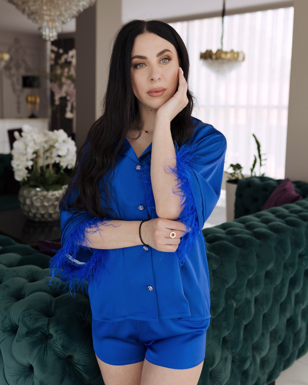 a woman is posing on a green couch