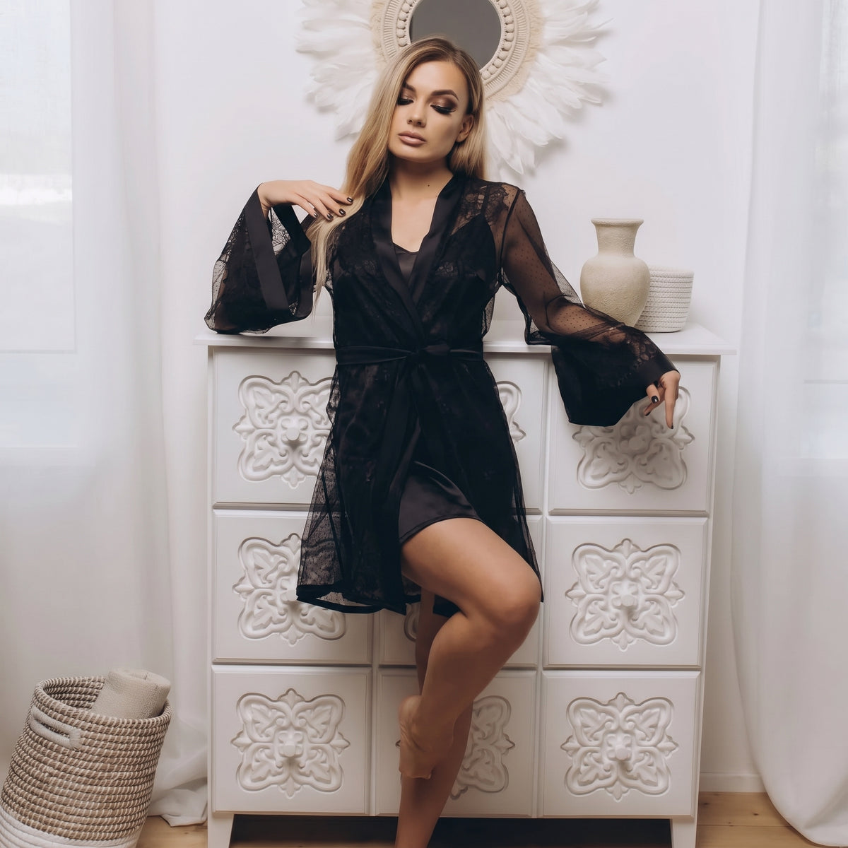 Front view of short black lace robe in airy tulle, showing the lightweight sheer fabric and adjustable waist tie indoors.