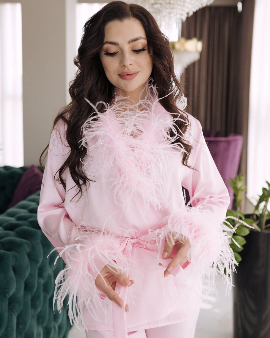 a woman wearing a pink outfit with feathers on it