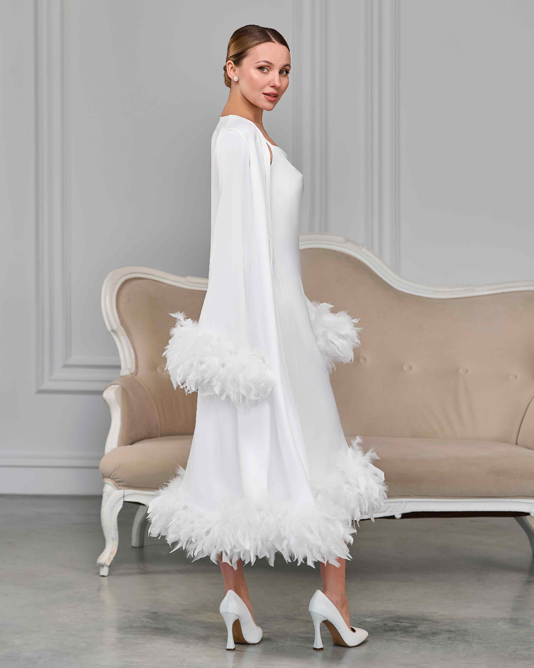 White bridal robe and slip dress with feather cuffs and hem, side view of model with vintage hairstyle
