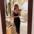 Below-the-knee black satin slip dress with draped neckline