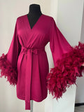 a pink dress with feathers on a mannequin