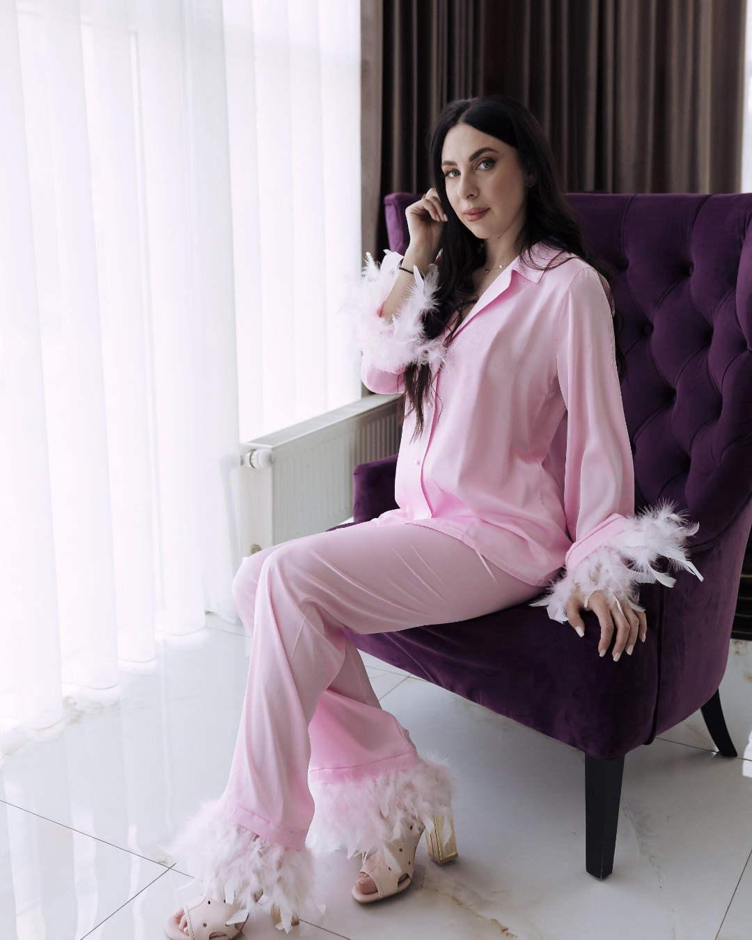 a woman sitting on a purple chair talking on a cell phone