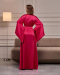Back view of a long fuchsia satin kimono robe with flowing sleeves