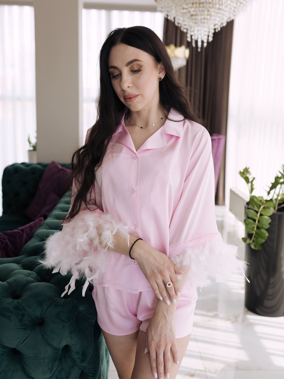 a woman in a pink shirt and shorts standing in front of a green couch