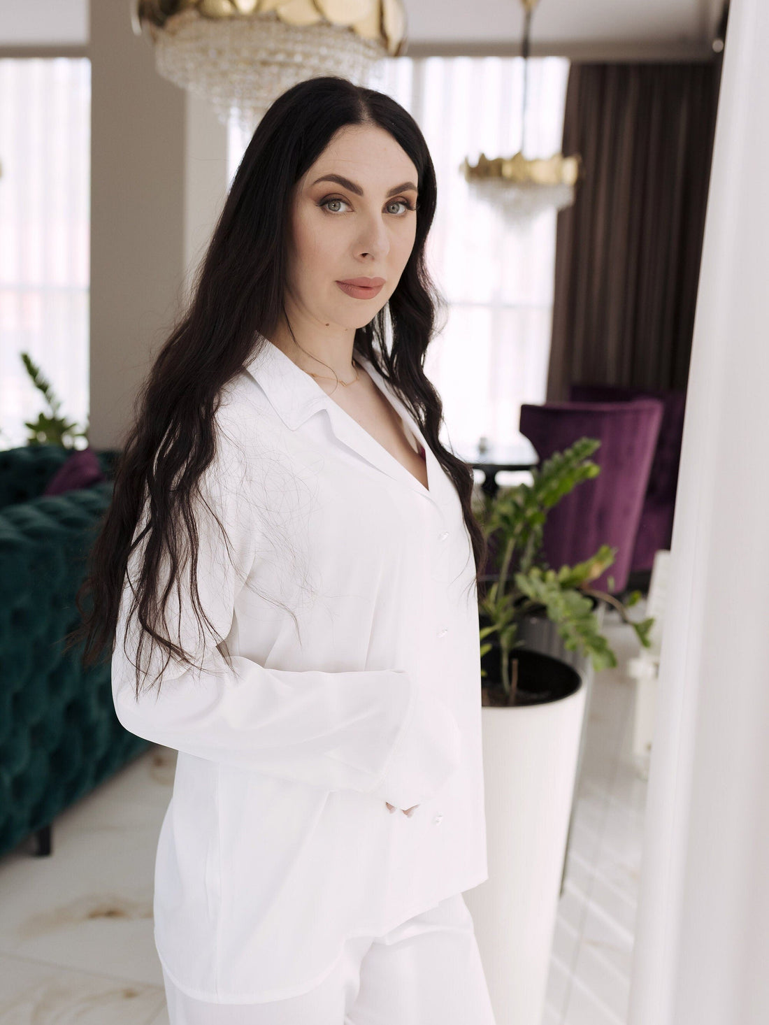 a woman is posing for a picture in a white outfit