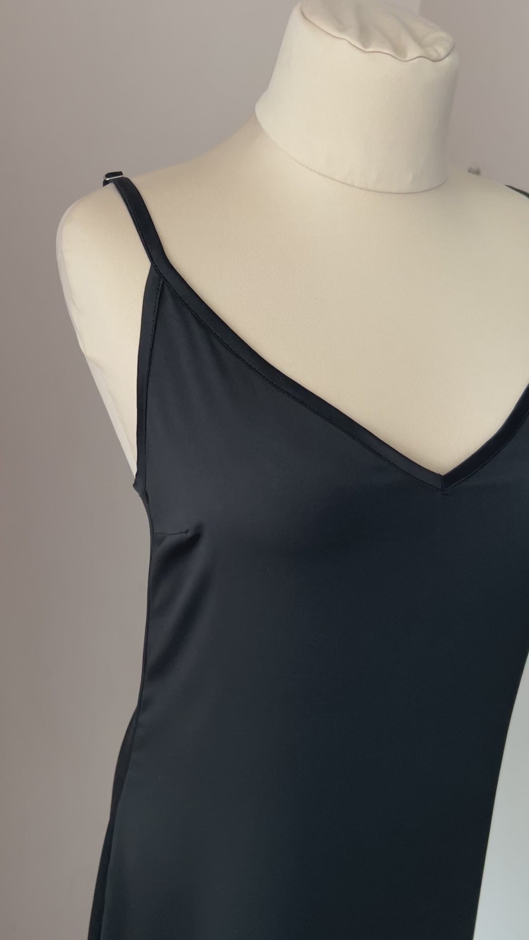 Video of a black satin nightgown with ostrich feather trim and an above-knee hem
