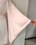 a woman's hand holding a pink dress on a hanger