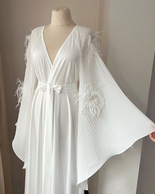 a white bridal robe on a mannequin in a room