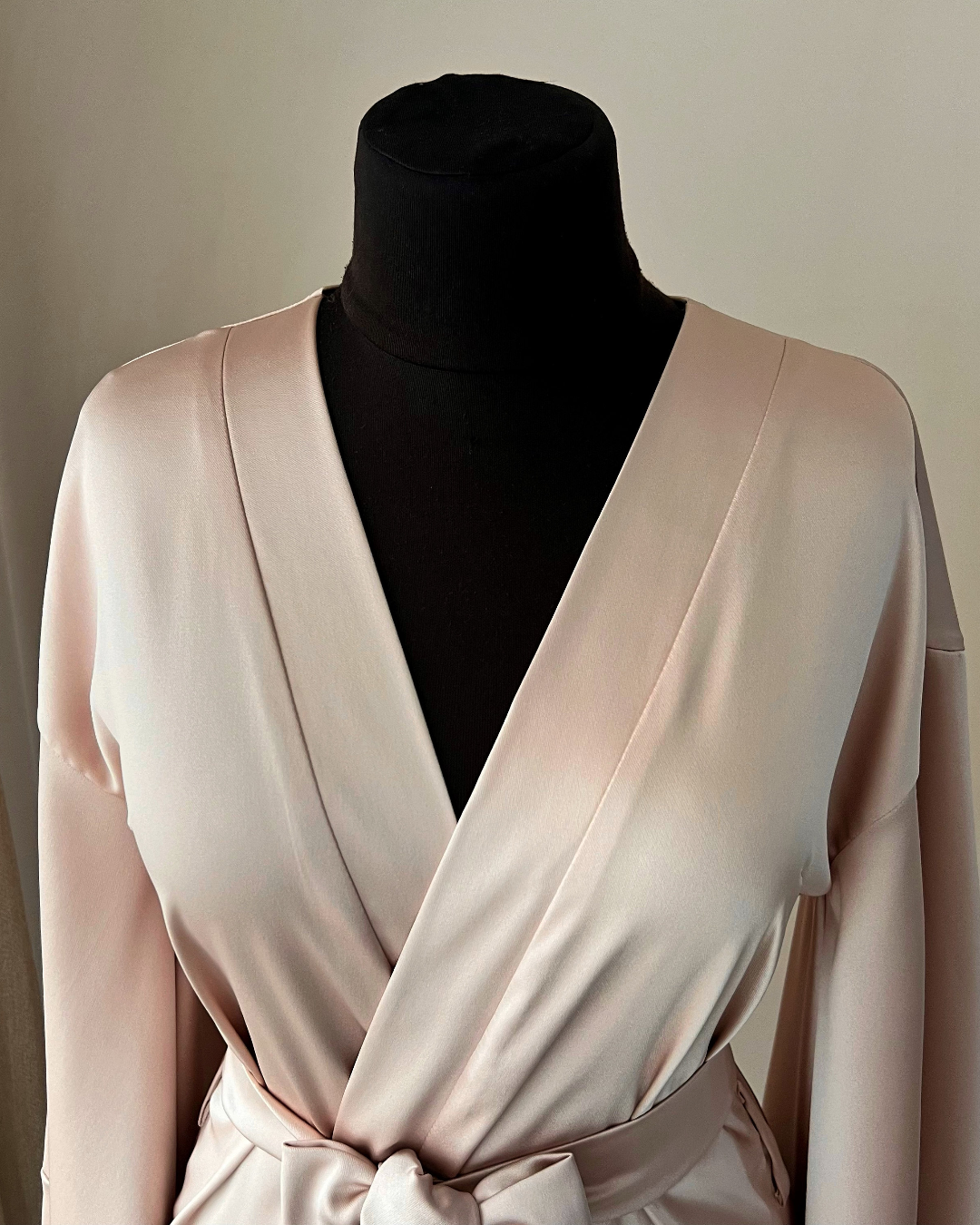 a mannequin wearing a pink dress with a black shirt underneath it