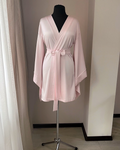 a pink robe sitting on top of a mannequin